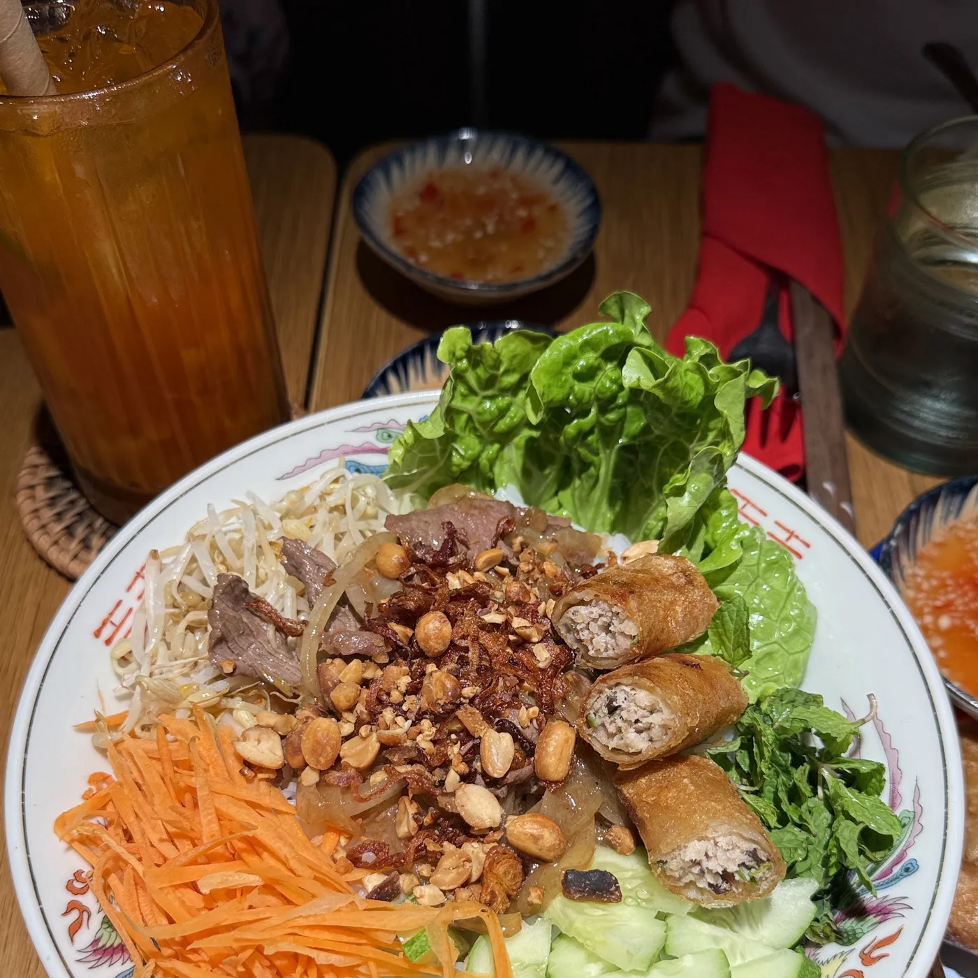 A cold rice noodle bowl with grilled pork, peanuts and herbs
