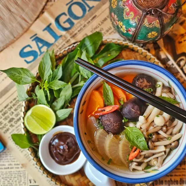 Chopsticks lifting rice noodles out of a bowl