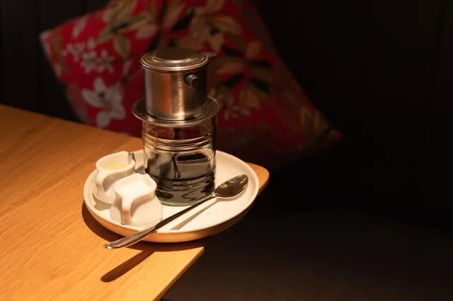 A Vietnamese phin filter dripping coffee into a glass