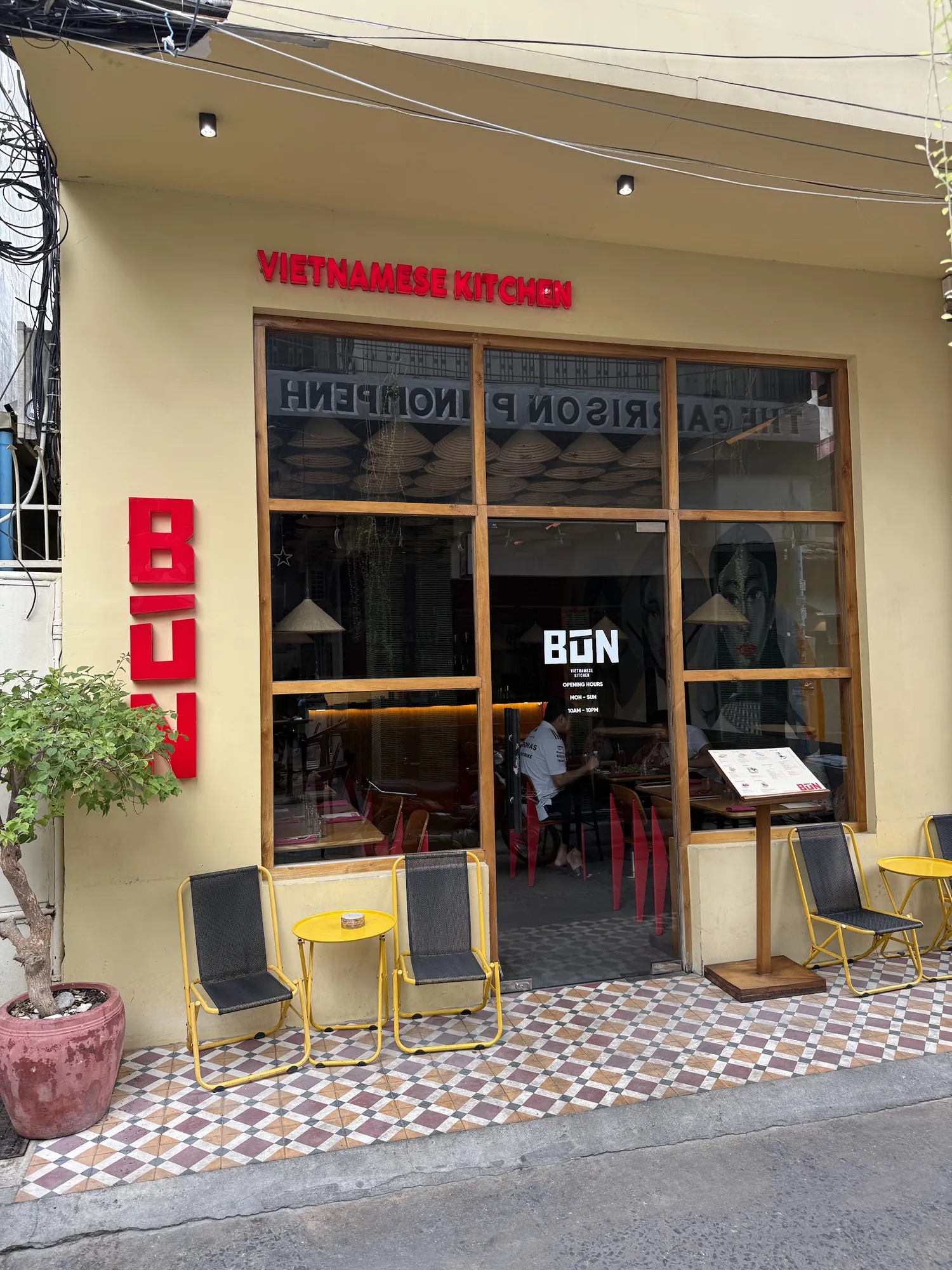 The Langka Lane shopfront with a red BÚN sign and yellow stools
